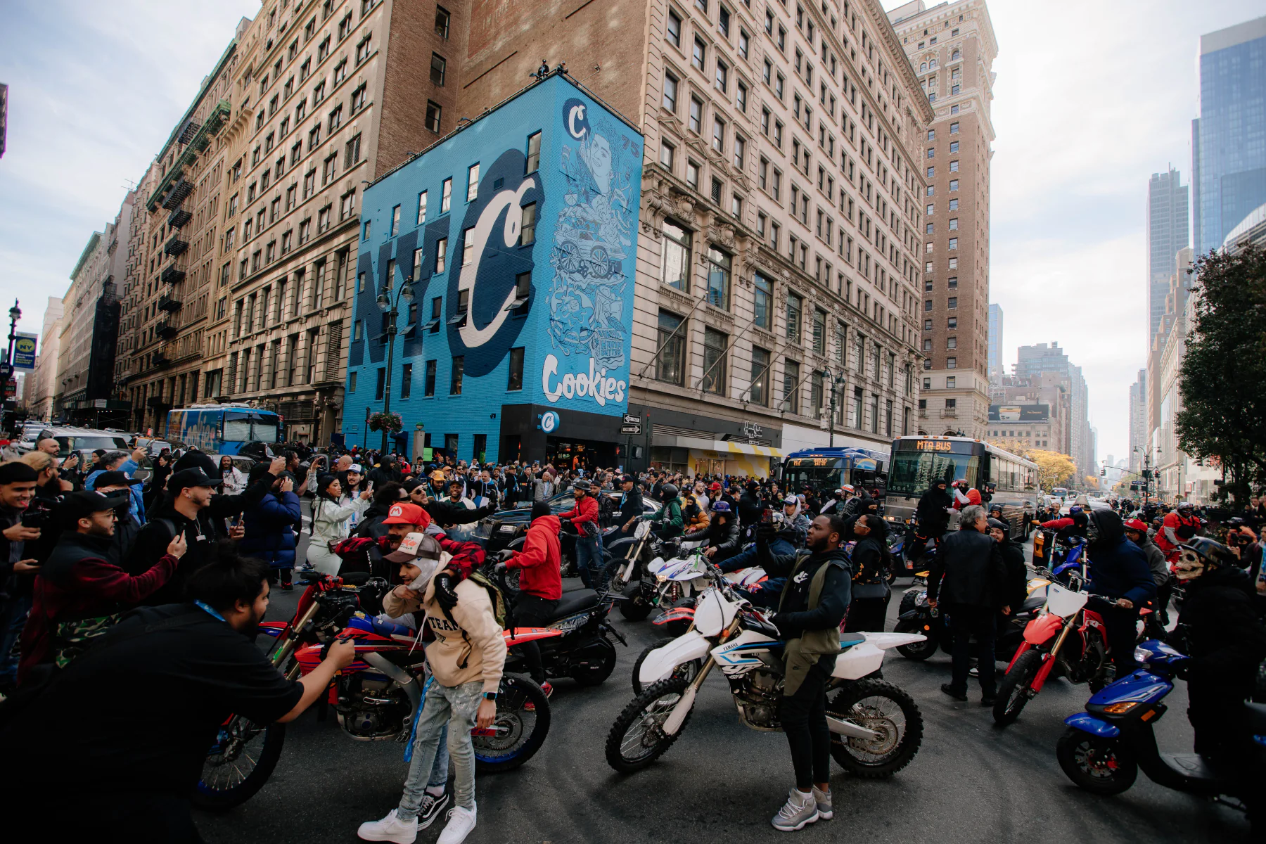 Crowd and motorcyclists gathered outside the blue Cookies storefront in New York